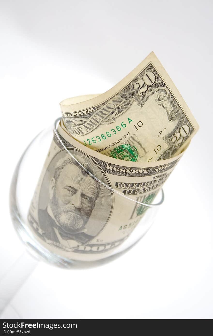 Dollar bills in the glass for wine isolated on light gray. Dollar bills in the glass for wine isolated on light gray