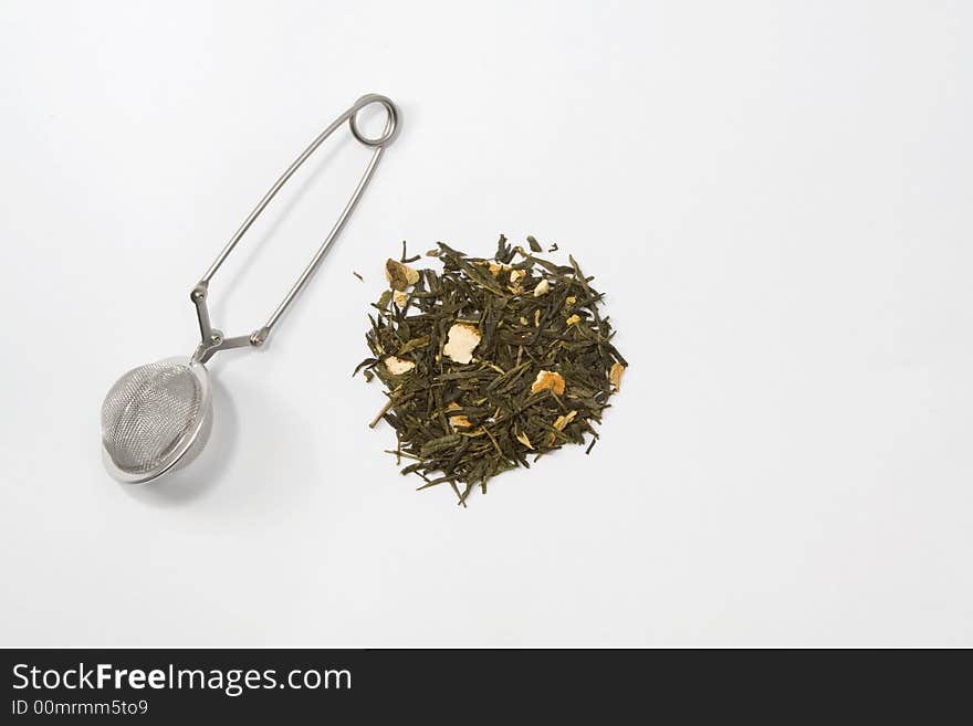 Tea skimmer with dried green tea leaves and orange husk