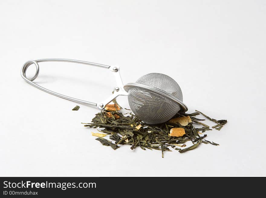 Tea skimmer with dried green tea leaves and orange husk