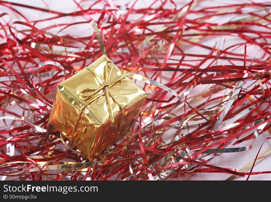 Gold gift box in red tinsel.