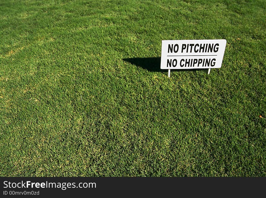 No Pitching, No Chipping sign in Lush Green Golf Course Grass.