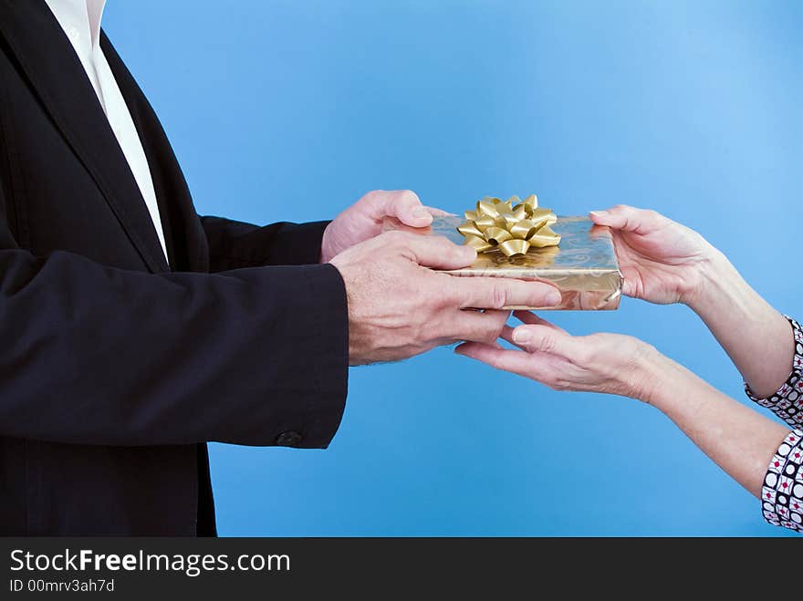 A man handing a woman a gift. A man handing a woman a gift.