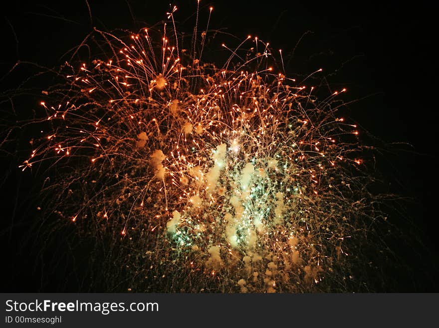 Fireworks lights and smoke in the night sky.