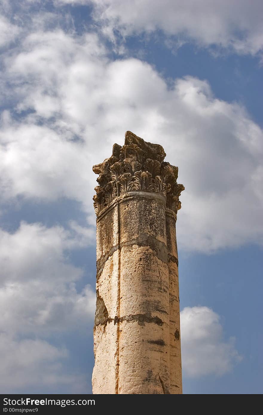 A high harmonous column in ancient port Caesaria on a background of the cloudy sky. A high harmonous column in ancient port Caesaria on a background of the cloudy sky