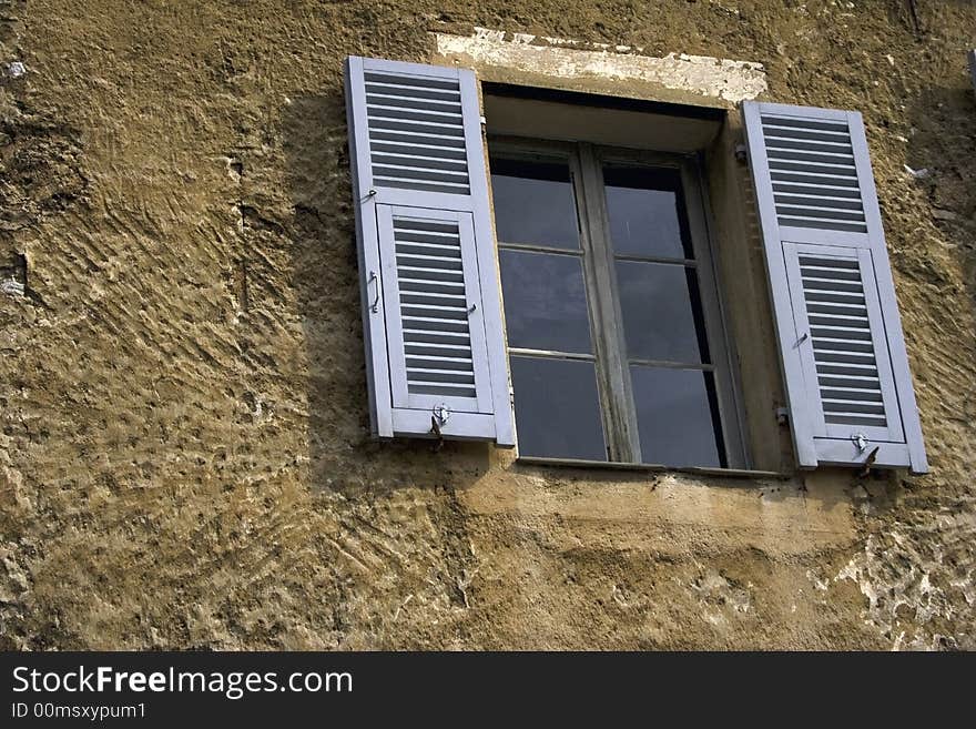 Window with gray shutters in the ancient house