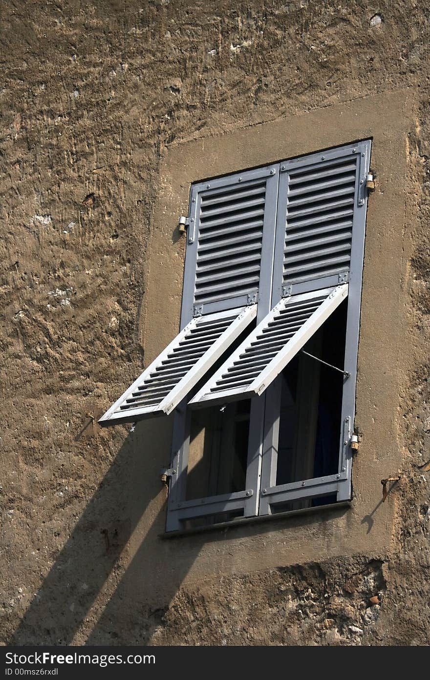 Window in the old rugged house with the gray shutters. Window in the old rugged house with the gray shutters