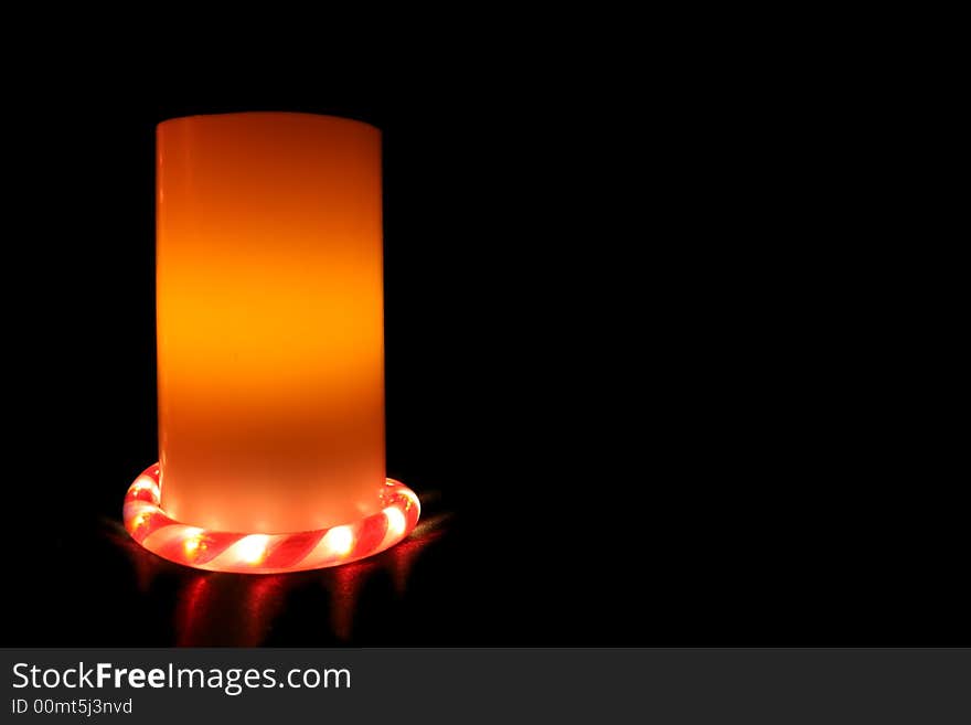 An Electric Candle on black background with candy cane light