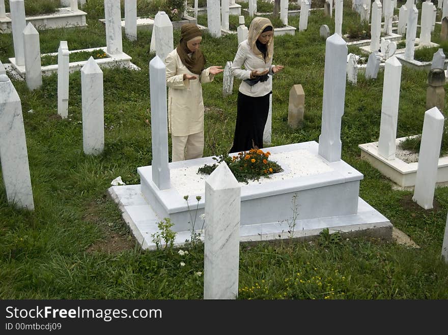 Two young female muslim girls on cemetery