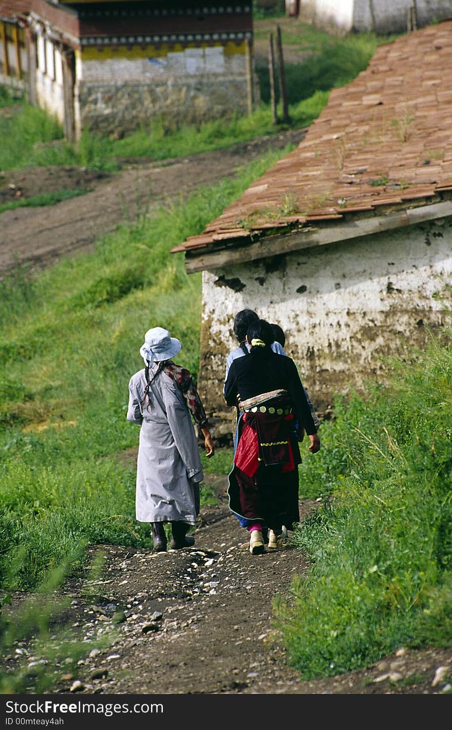 Tibetans walk on the road.Gansu province,China.