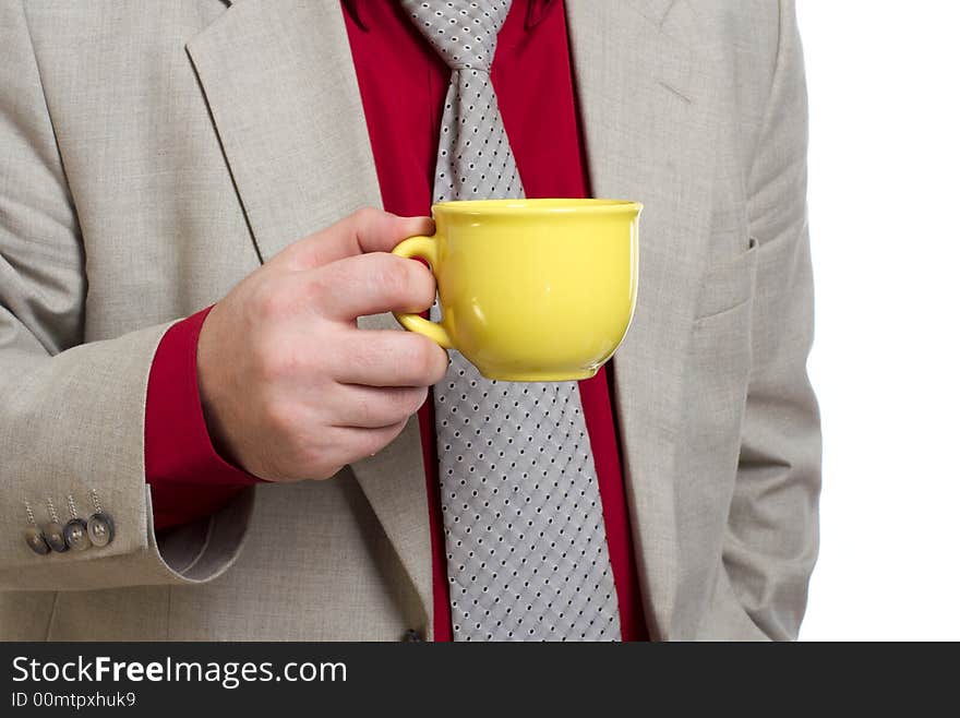 The man holds a yellow cup with tea. The man holds a yellow cup with tea