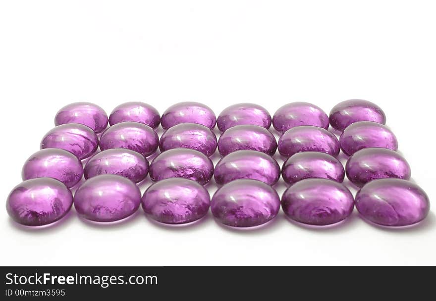 Violet glass pebbles on the white background