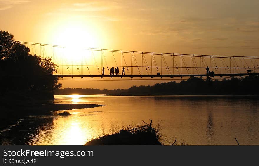 Sunset moment at riverside rope bridge & tourist people. Sunset moment at riverside rope bridge & tourist people