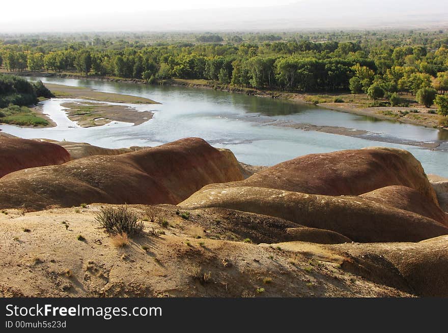 Miticolored stone at riverside and green forest at the other side. Miticolored stone at riverside and green forest at the other side