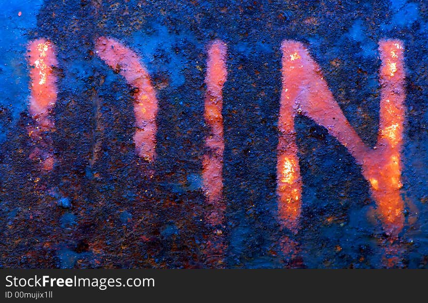 Image shows a metallic surface with the letters D, I, N been faded by rust and weathering. Image shows a metallic surface with the letters D, I, N been faded by rust and weathering