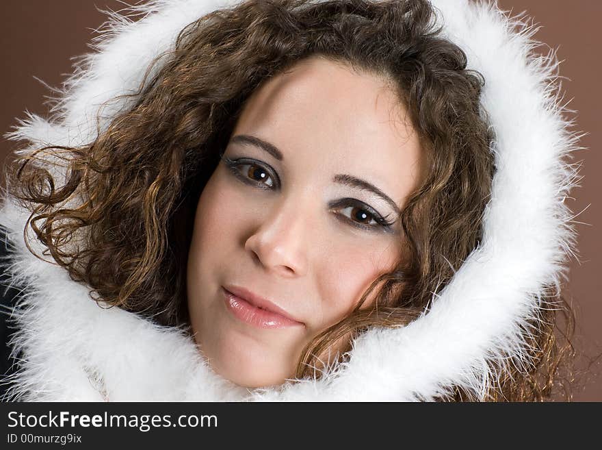 Young woman slight smiling with fluffy feather on her head. Young woman slight smiling with fluffy feather on her head.