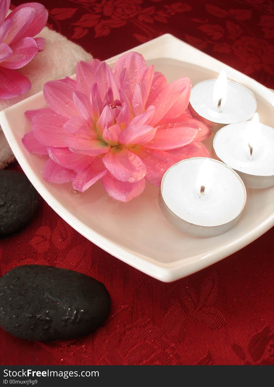 Spa essentials (candles, flowers on water, towel and stones)