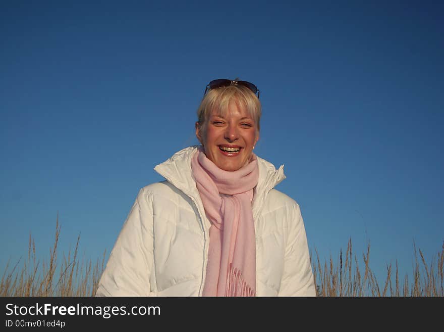 Portrait of a young attractive girl at autumn day on the blue sky background. Portrait of a young attractive girl at autumn day on the blue sky background