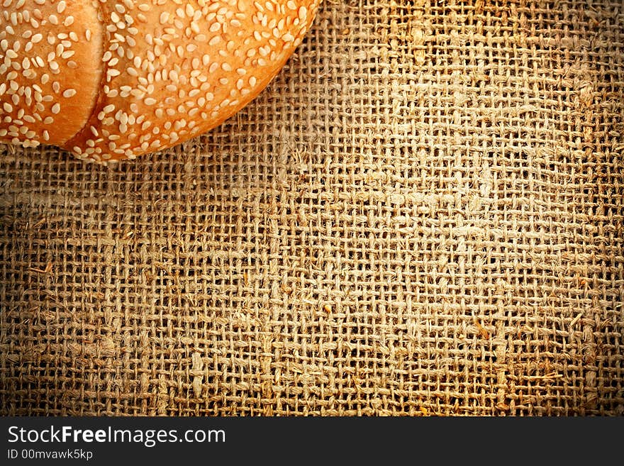 Croissant with sesame on a sacking background. Croissant with sesame on a sacking background