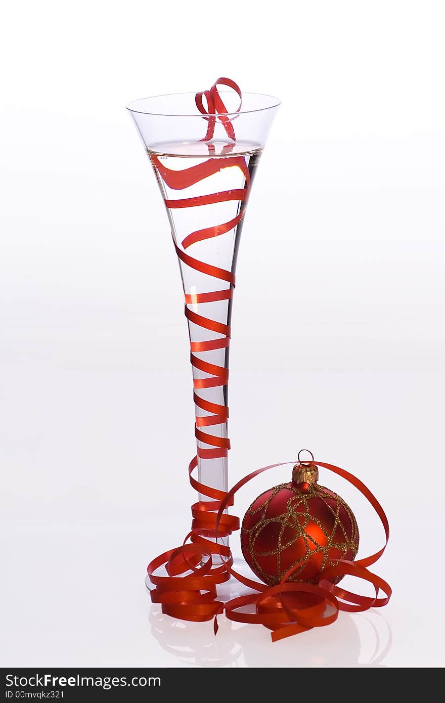 Glass of champagne decorated red ribbon and christmas ball