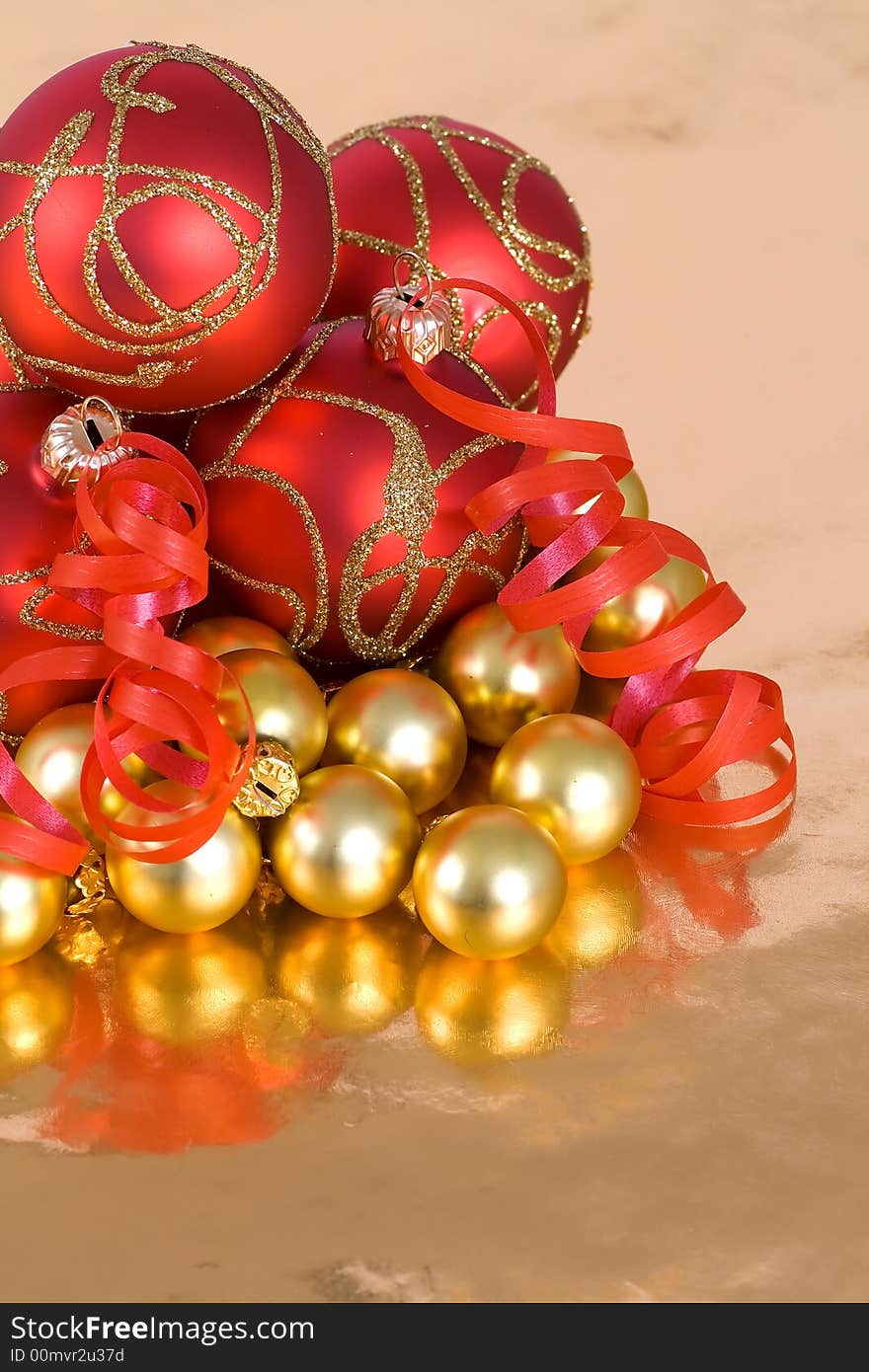 Christmas red and  gold  balls with ribbon on  the gold  background. Christmas red and  gold  balls with ribbon on  the gold  background