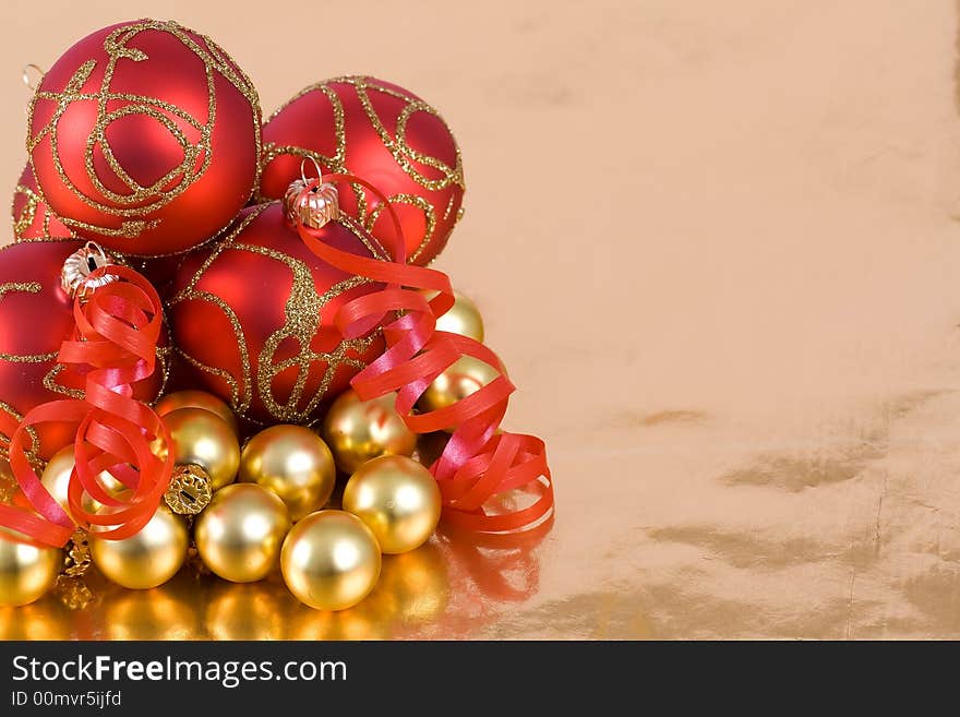 Christmas red and  gold  balls with ribbon on  the gold  background. Christmas red and  gold  balls with ribbon on  the gold  background