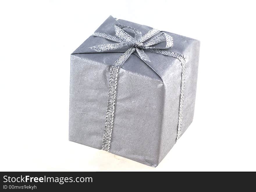 Present wrapped in silver paper isolated on white. Present wrapped in silver paper isolated on white.