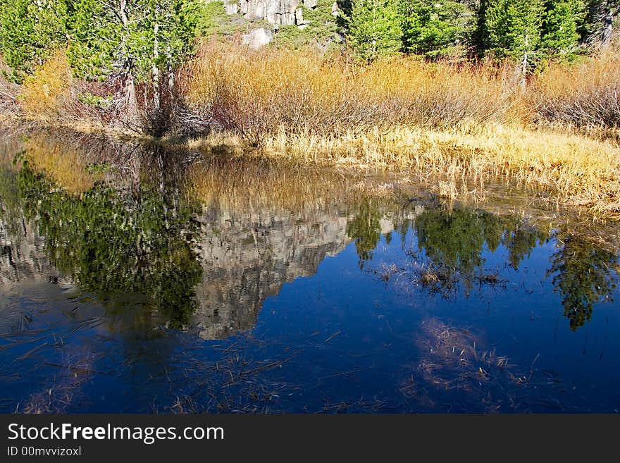 Reflection of rocky mountain in very blue water pond. Reflection of rocky mountain in very blue water pond