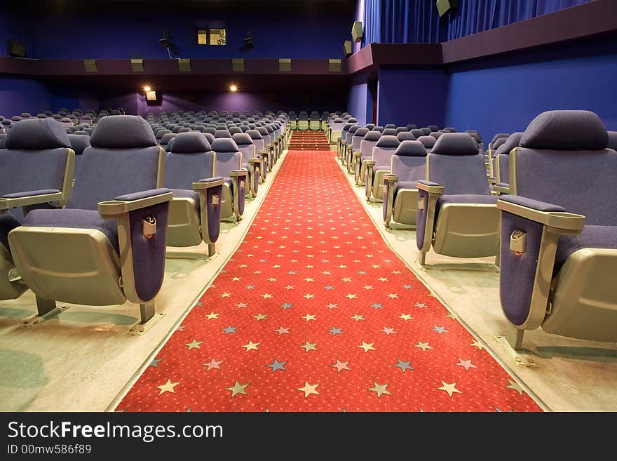 Empty cinema auditorium with blue chairs