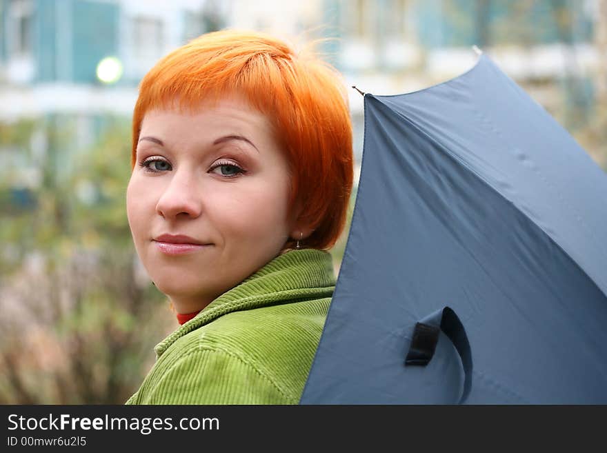 Young red-haired woman with umbrella