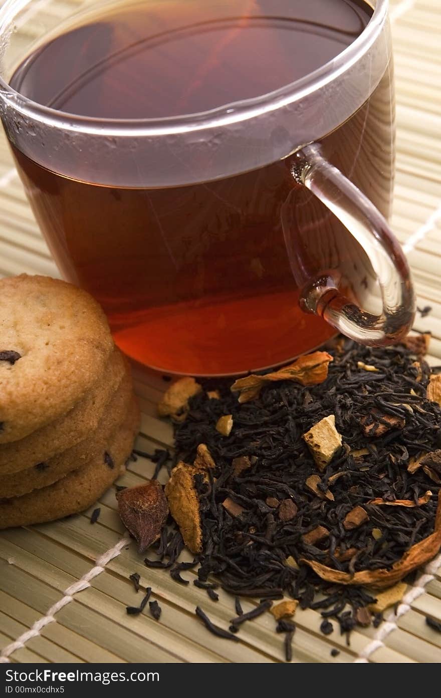 Glass tea, dried tea leaves and cookies. Glass tea, dried tea leaves and cookies