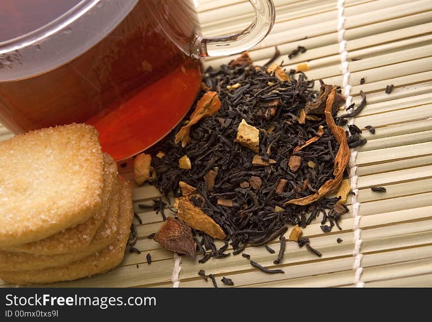 Glass tea, dried tea leaves and cookies. Glass tea, dried tea leaves and cookies