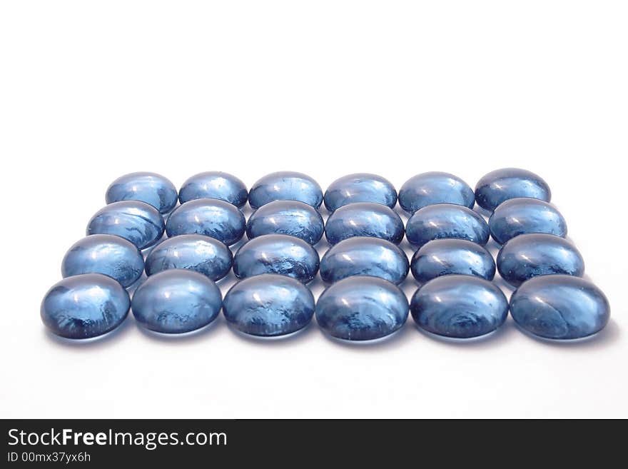 Blue glass pebbles on the white background