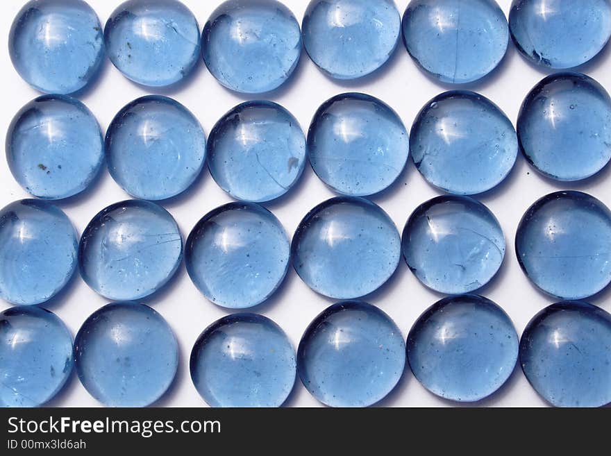 Blue glass pebbles on the white background