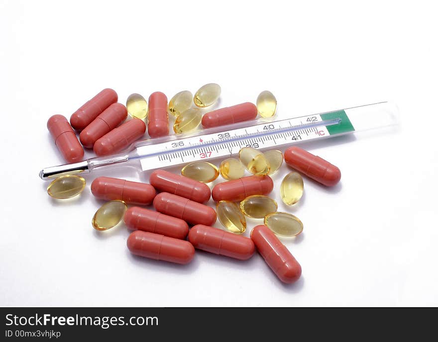 Many pills and thermometer on the white background. Many pills and thermometer on the white background