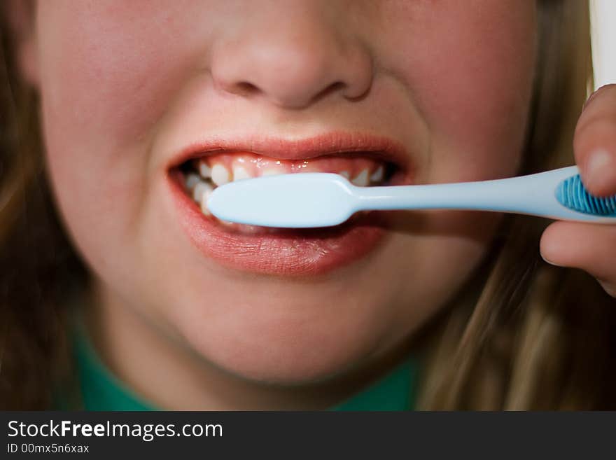 Closeup of older child brushing teeth