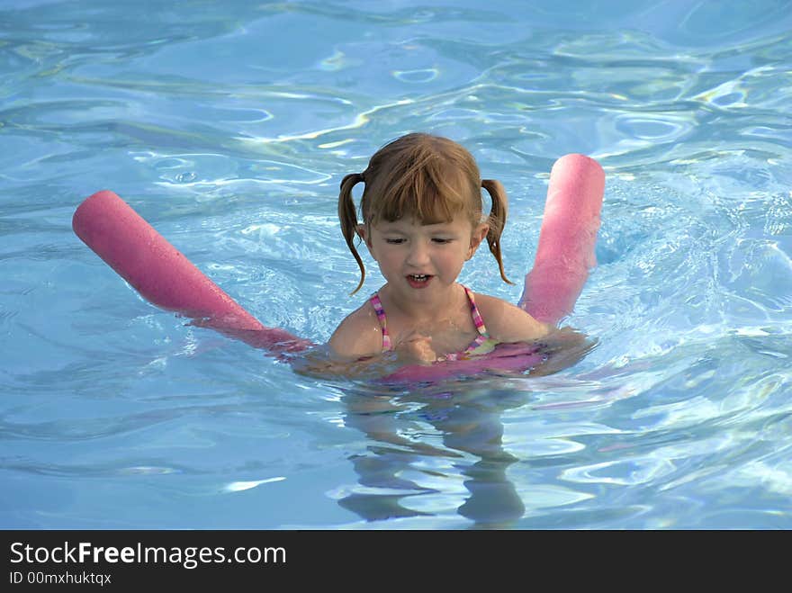 Young girl in swimming pool flipping wet hair. Young girl in swimming pool flipping wet hair