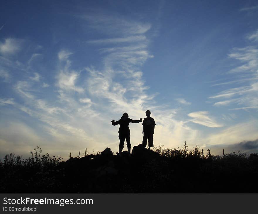 A silhouette of a grazing horse in a landscape while the sun sets. A silhouette of a grazing horse in a landscape while the sun sets.