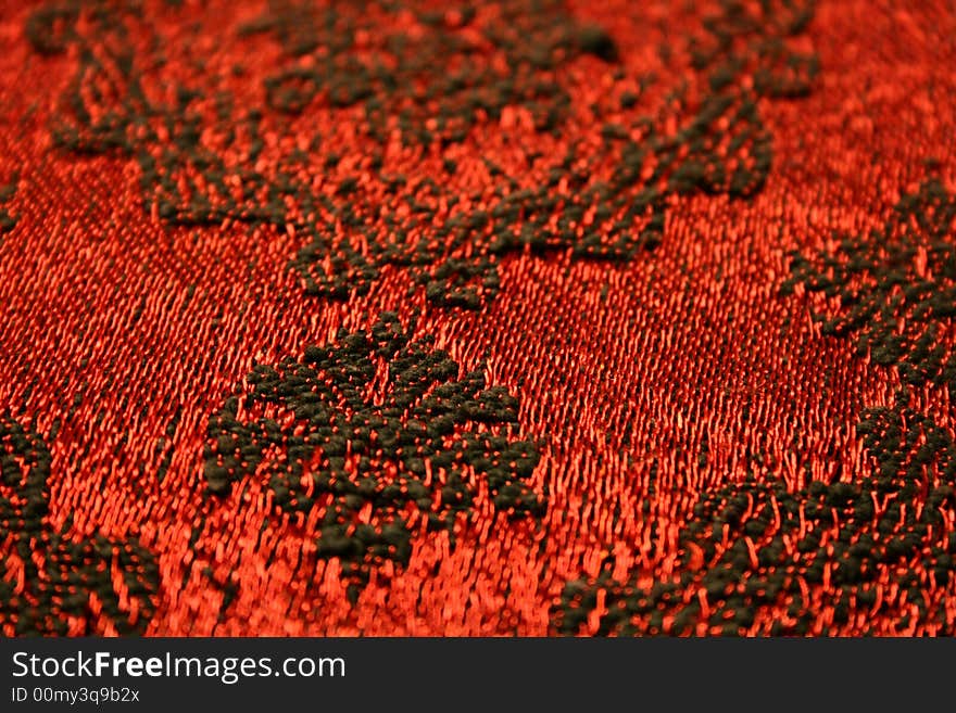 Red blanket with black ornaments, a detail.