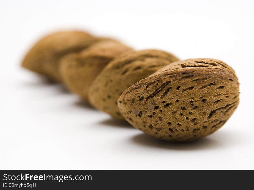 Four almonds aligned on a white table