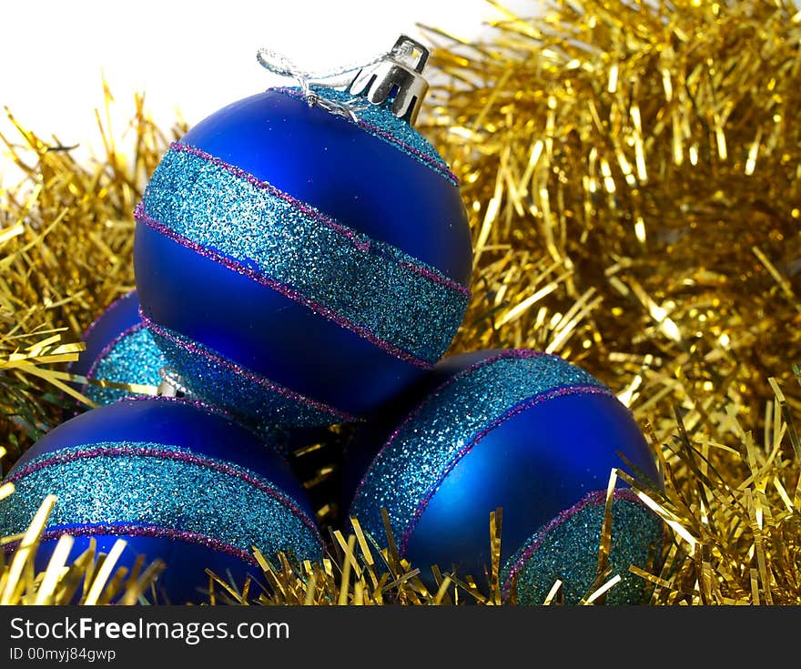 Christmas blue ornaments and gold tinsel on white background