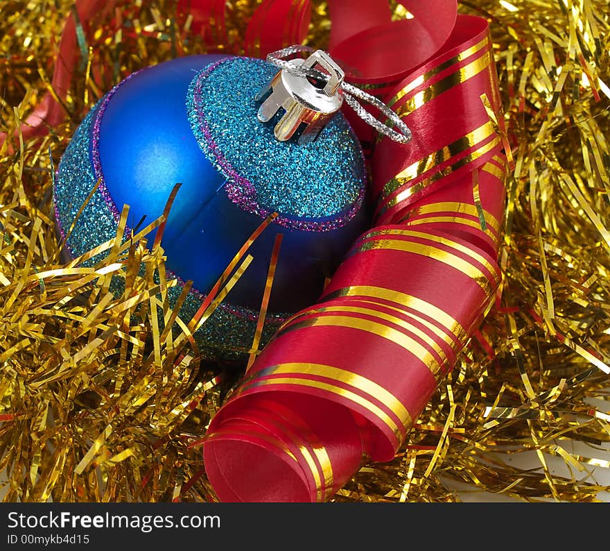 Christmas blue ornaments and colorfull  ribbon on background of gold tinselbackground. Christmas blue ornaments and colorfull  ribbon on background of gold tinselbackground