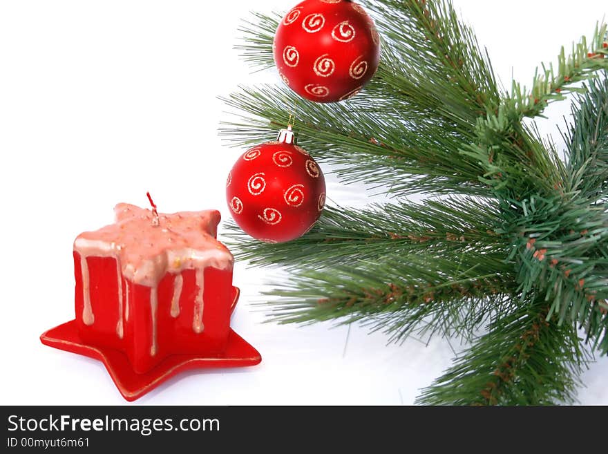 Christmas red balls on the fir-tree and red candle.