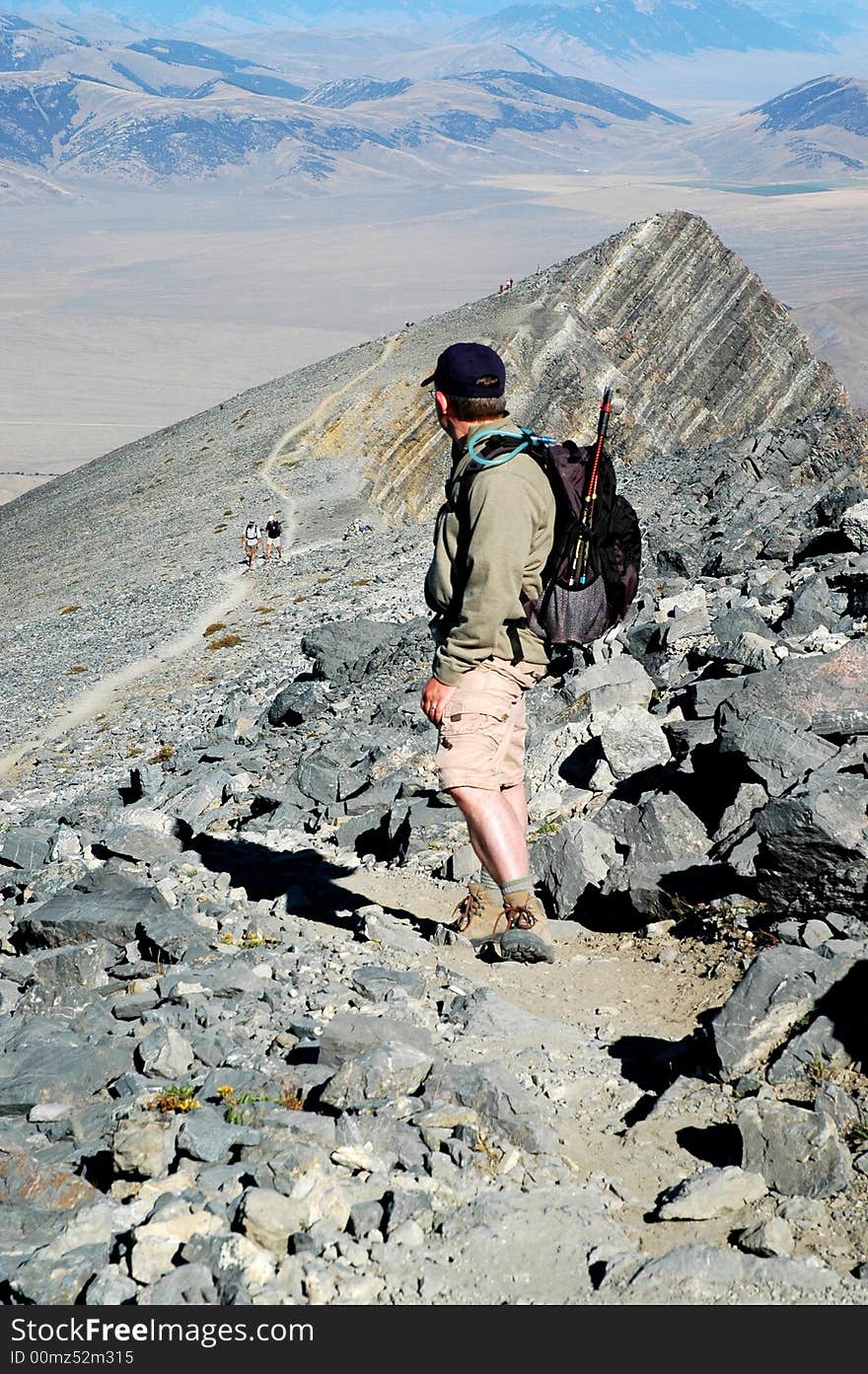 Several people climbing along rocky ridge on a trail. Several people climbing along rocky ridge on a trail