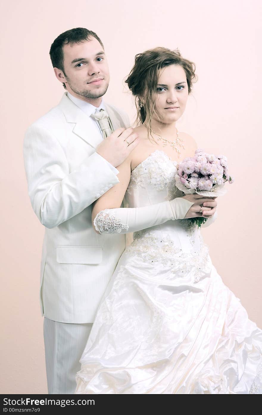 Young couple in wedding wear with bouquet of chrysanthemum. Special pink toned photo f/x