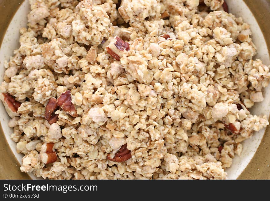 Bowl of crumbly wheat and corn cereal with nutty bits in milk