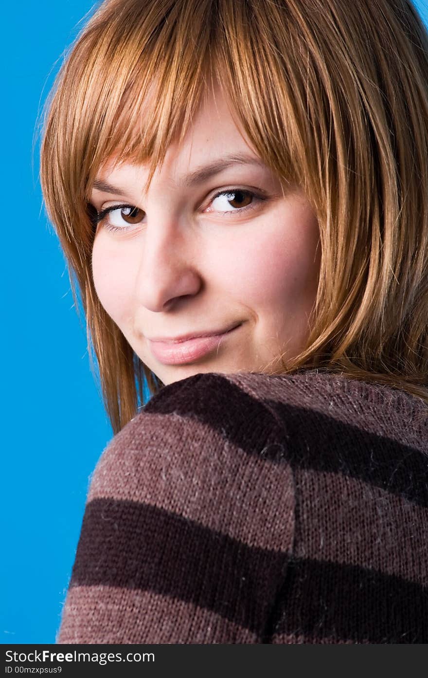 The girl playfully looks, isolated on a dark blue background. The girl playfully looks, isolated on a dark blue background.