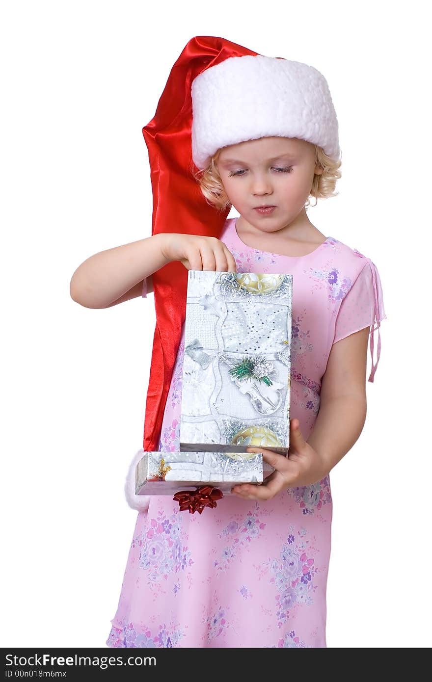 Cute fair-haired girl in Santa's hat getting out present  from the box. Cute fair-haired girl in Santa's hat getting out present  from the box