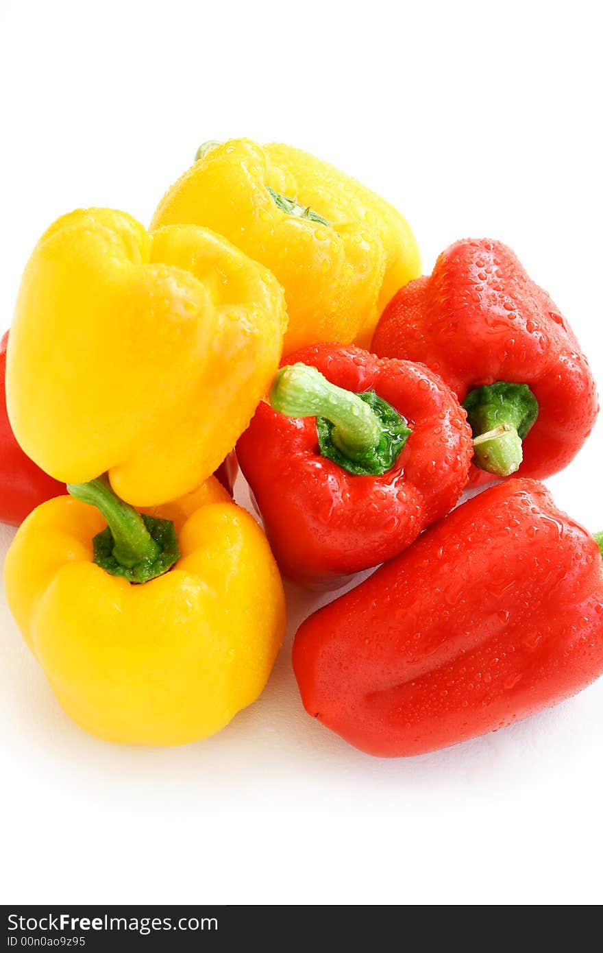 Pile of red and yellow paprikas in shiny water droplets