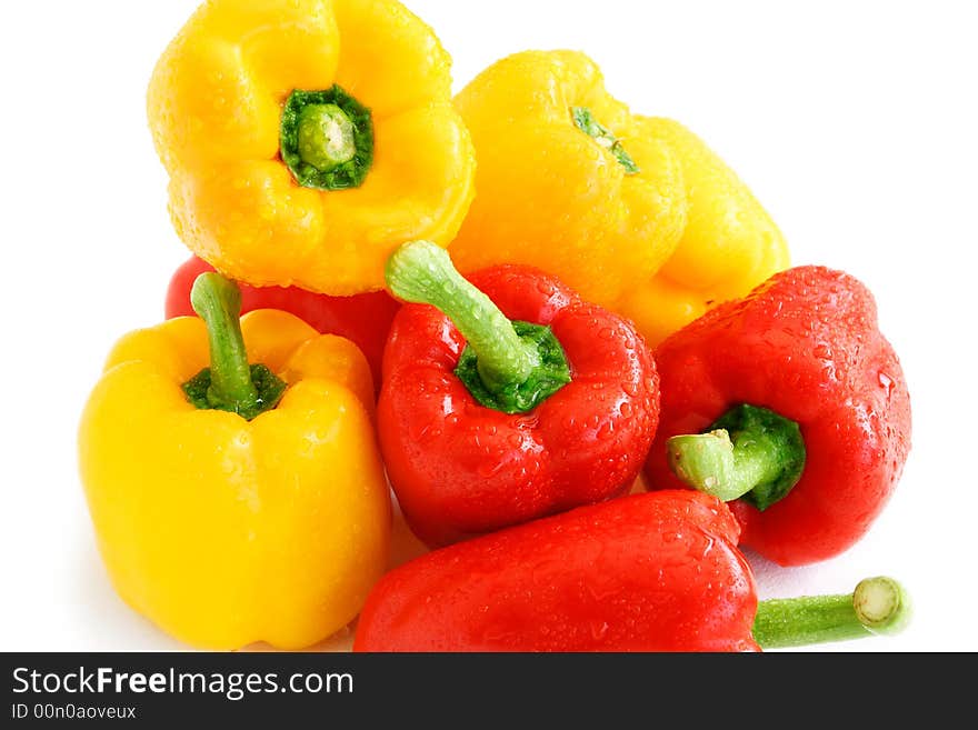 Pile of red and yellow paprikas in shiny water droplets