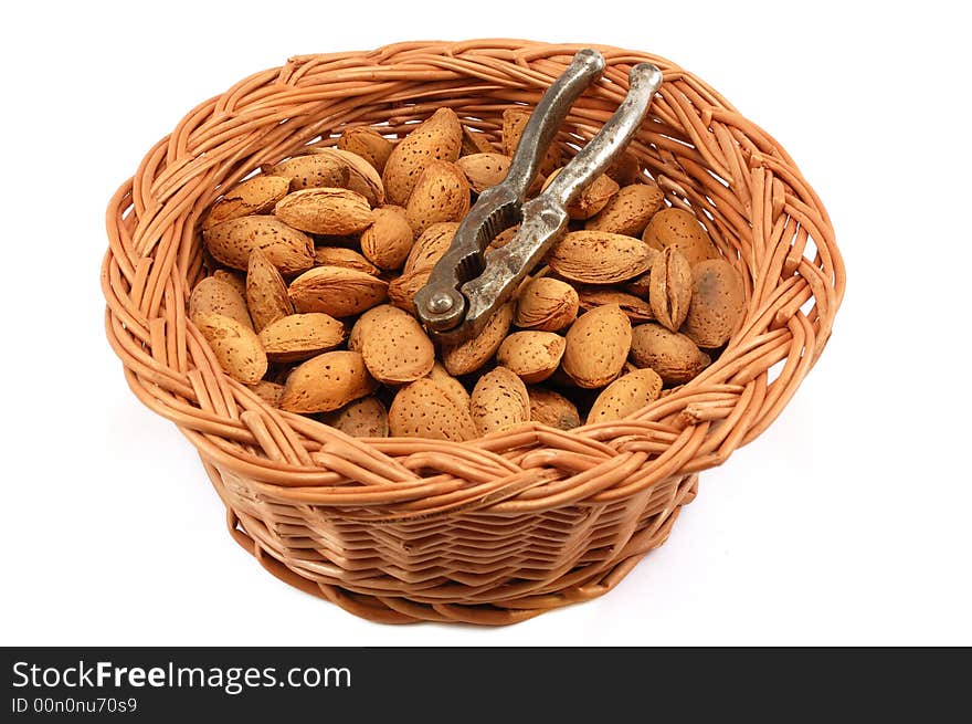 Whole almonds with nutcracker in a basket against white background. Whole almonds with nutcracker in a basket against white background.